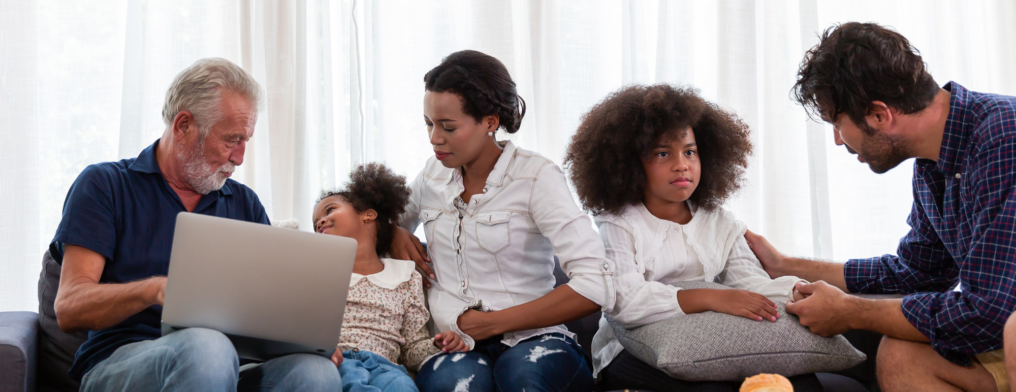 Family on couch looking at laptop